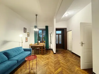 a living room with a blue couch and a table at Batory's Tavern in Kraków