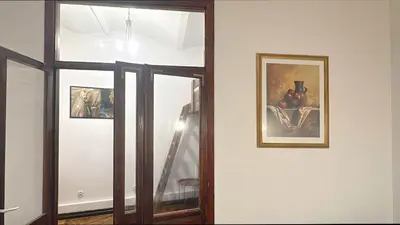 a room with two pictures on the wall and a mirror at Batory's Tavern in Kraków