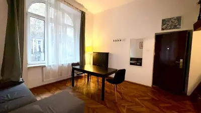 a living room with a table and a window at Krakow Center Apartment in Kraków