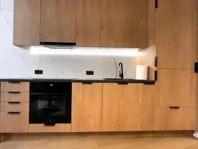 a kitchen with wooden cabinets and a sink and a stove at Krakow Center Apartment in Kraków