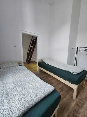 two beds sitting in a room with a staircase at Top Apartment in Kraków