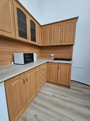a kitchen with wooden cabinets and a microwave at Top Apartment in Kraków
