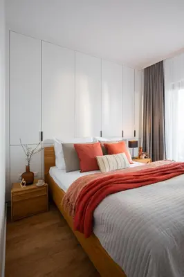 a bedroom with a large bed with orange and white pillows at Apartamenty Lew Invest obok Rynku Głównego 255, Parking w cenie in Kraków