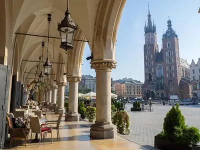 a building with an arch with tables and chairs at Apartment next to Wawel Castle and the Vistula River, air conditioning in Kraków