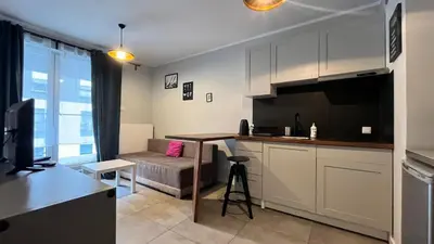 a kitchen with a table and a couch in a room at Small Apartment in Kraków