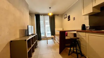 a small kitchen with a counter and a television at Small Apartment in Kraków