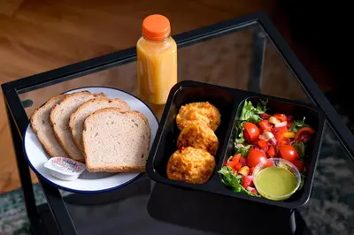 a lunch box with a plate of food and bread and vegetables at Native Apartments Kościuszki 39I19 in Kraków