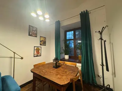 a dining room with a table and green curtains at Tawerna Krakowska in Kraków