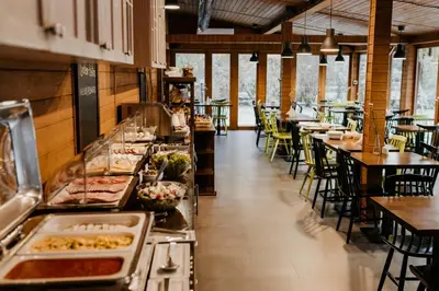a restaurant with a buffet line with tables and chairs at Zulian Aparthotel by Artery Hotels in Kraków