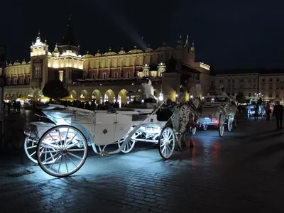 a horse drawn carriage parked in front of a building at Cracowapart Loft Gertruda in Kraków