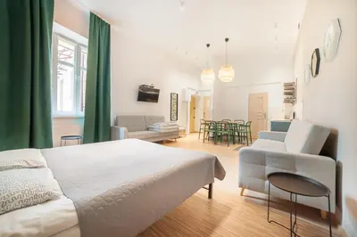 a bedroom with a bed and a living room at Dizzy Daisy Downtown Apartments in Kraków
