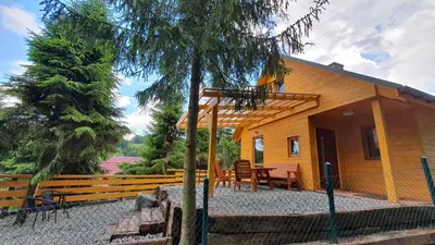 a cabin with a table and chairs in front of it at Zawoja Chaty Górskie D1 in Zawoja