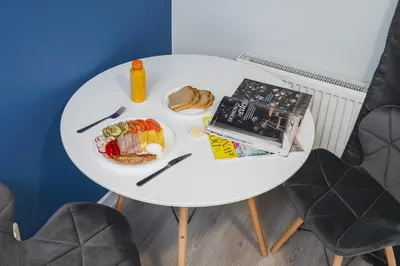 a white table with a plate of food on it at Grace Apartments in Kraków