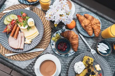 a table with plates of food and croissants and coffee at Avium Old Town Apartments in Kraków