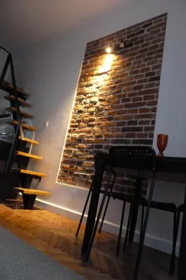 a room with a brick wall with a table and a chair at City Space Apartments in Kraków