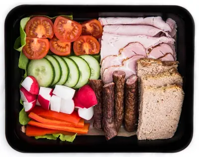 a lunch box with meat and vegetables and bread at Aparthotel BC 29 Residence in Kraków