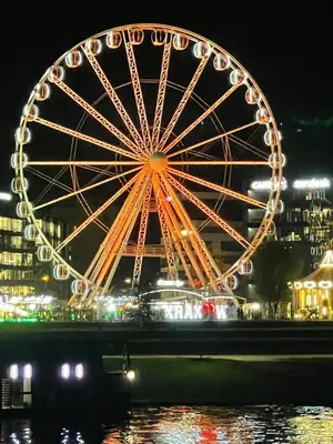 a ferris wheel in a city at night at Jacuzzi & Bike Apartment, Krakow in Kraków