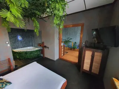 a room with a tub and a bed and a television at Apartament z jacuzzi Kraków in Kraków