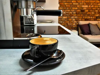 a cup of coffee on a counter with a spoon at Way2Stay Bosacka in Kraków