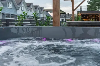 a hot tub with pink lighting in a backyard at Old Tree Village & Restaurant in Oświęcim