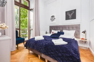 a bedroom with a bed with a blue comforter at The Old Town View in Kraków