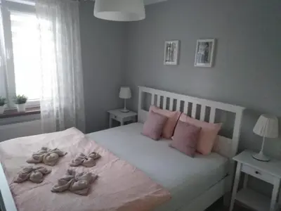 a bedroom with a bed with shoes on it at Apartament Antek klimatyzowany in Oświęcim