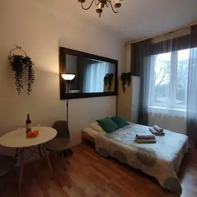 a bedroom with a bed and a table and a window at Your trip apartment (2) in Kraków