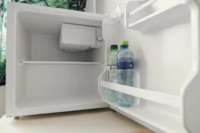 two bottles of water sitting inside of an open refrigerator at Your trip apartment (2) in Kraków