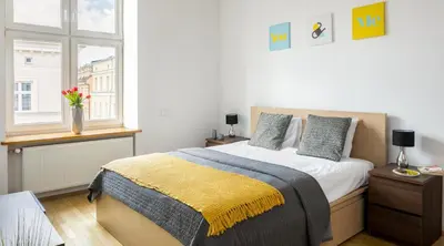 a bedroom with a large bed and a window at City View Apartments in Kraków
