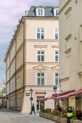 a man walking down a street in front of a building at City View Apartments in Kraków