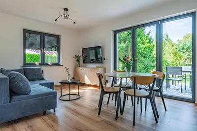 a living room with a couch and a table and chairs at Dworek na Zakręcie - noclegi Zator in Zator