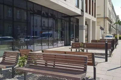 a row of benches on a sidewalk in front of a building at BOUTIQUE 108 - old city, luxury apt. with a garage in Kraków