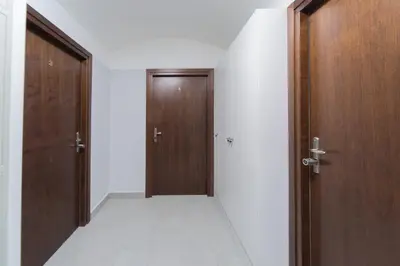 an empty hallway with two wooden doors and a floor at M3 Main Square Studio in Kraków