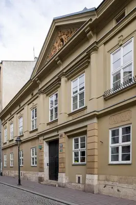 a large yellow building with a door on a street at LUXURY Apartment at the Main Square in Kraków