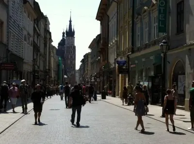 a group of people walking down a busy city street at Floriańska Grand Apartment 2 in Kraków