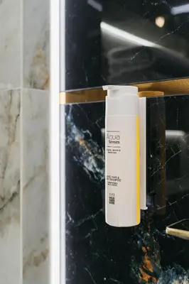 a bottle of sunscreen sitting on a counter in a bathroom at Native Apartments Batorego 7- Bardzo ciche i spokojne miejsce in Kraków