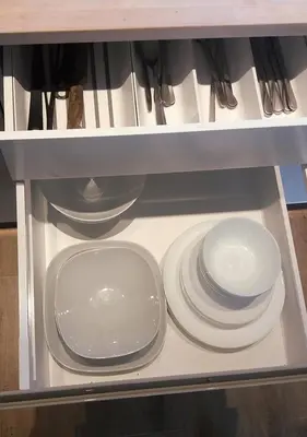 a drawer filled with white plates and utensils at Apartamenty-Obok 1 in Zator
