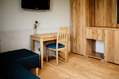 a room with a wooden table and a chair at Róża Rooms in Zator