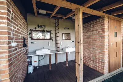 a bathroom with two sinks and a brick wall at Kogutowo Agroturystyka MPR in Wietrzychowice