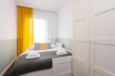 a bedroom with a bed and a yellow curtain at Old Town Rakowicka by NEARTO in Kraków