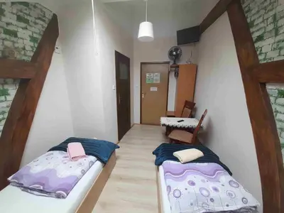 a room with two beds and a table in it at Kraków Hostel in Kraków