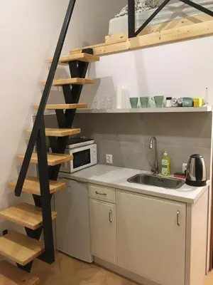 a kitchen with a sink and a spiral staircase at Pure Apartments in Kraków