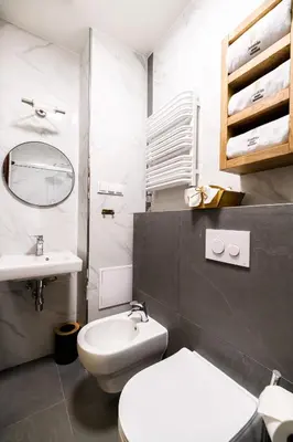 a bathroom with a white toilet and a sink at Apart Residence Ariańska 16 by NEARTO PL in Kraków