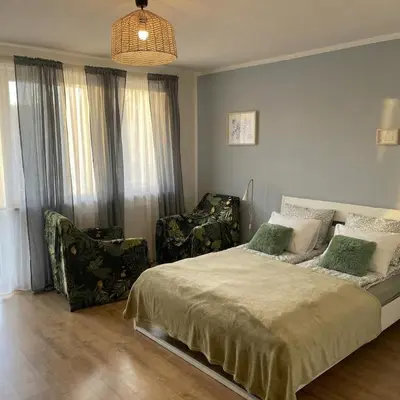 a bedroom with a bed and two chairs at Beautiful apartment with balcony in Kraków