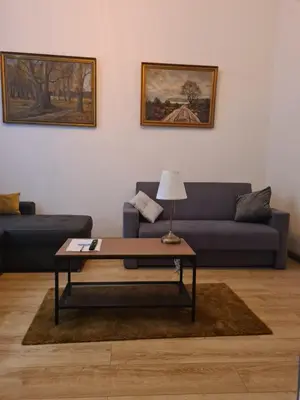 a living room with a blue couch and a coffee table at AMBER APARTAMENT 1112 in Kraków