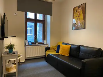 a living room with a black couch and yellow pillows at Milla Apartments in Kraków