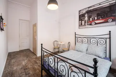 a bedroom with a bed and a picture of a car on the wall at Krakus in Kraków