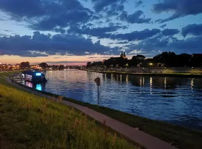 a blue boat on a river at night at Spa Bath Apartment in Kraków