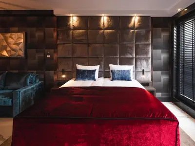 a bedroom with a large bed with a red blanket at Art Penthouse with Jacuzzi - Krakow Center in Kraków