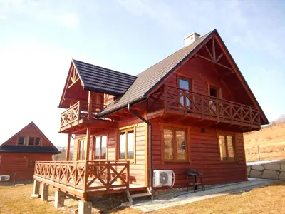 a log cabin with a gambrel roof at Dom Słoneczna Chata Kasina Wielka in Kasina Wielka